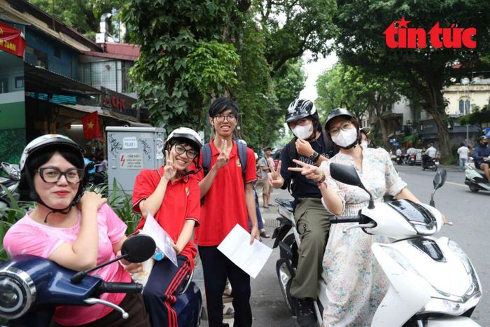 Nhóm phụ huynh, học sinh tại điểm thi Trường THPT Trần Phú - Hoàn Kiếm check in trước khi rời điểm thi. Nhiều phụ huynh chia sẻ, bên ngoài đợi con thi tâm trạng lo lắng nhưng khi thấy con chỉ còn lại là sự động viên và cái ôm để con vơi bớt những căng thẳng.