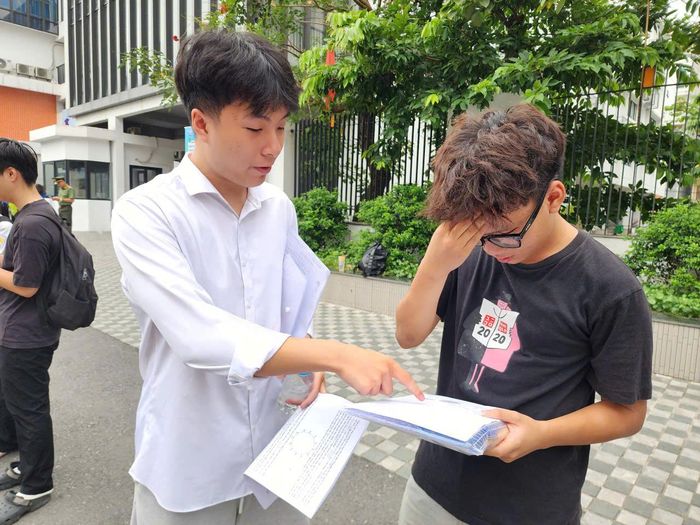 Các thí sinh trao đổi bài làm sau khi kết thúc môn thi tại điểm thi Trường THCS Kim Liên, Hà Nội.