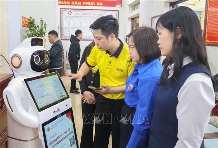 Cán bộ Trung tâm phục vụ hành chính công xã Quỹ Nhất hướng dẫn người dân thao tác trên Robot Lễ tân AI. Ảnh: Công Luật/TTXVN