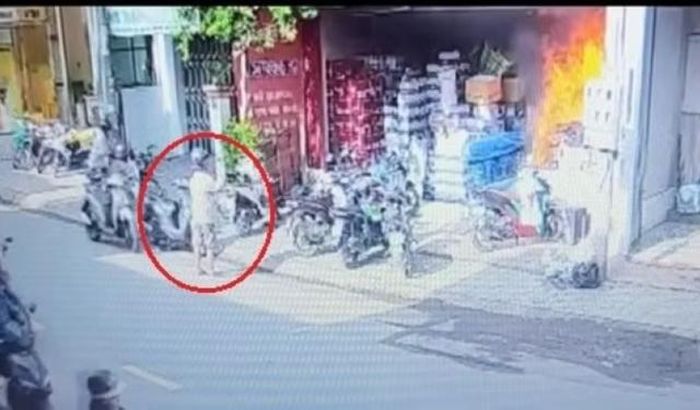 Ngọn lửa bùng lên, người trong nhà chạy ra, Lynh đứng lại xem rồi mới lên xe máy rời đi. Ảnh cắt từ clip.