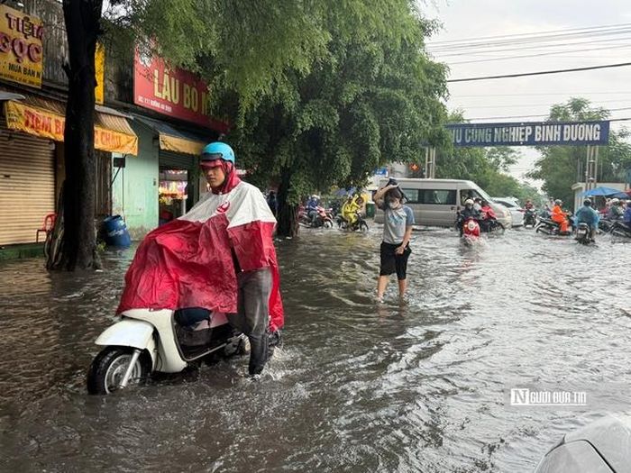 Khu vực đường An Bình, trước cổng Khu công nghiệp Bình Đường ngập úng, khiến người dâu đi lại khó khăn trong cơn mưa đầu tháng 6/2026.