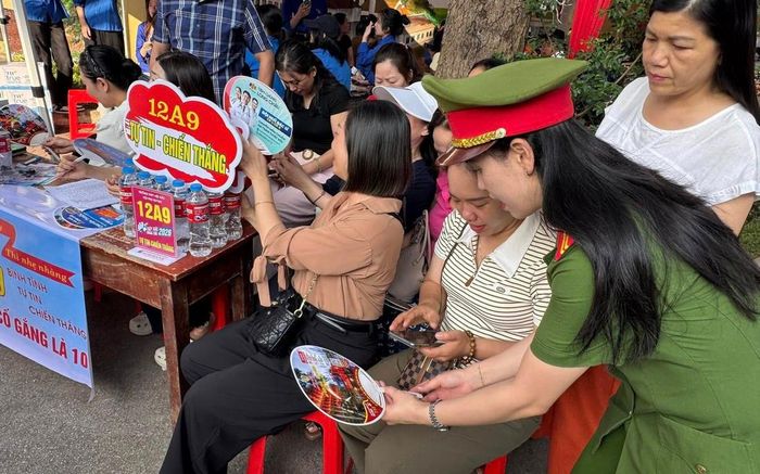 Cán bộ, chiến sĩ Công an Lạng Sơn hướng dẫn phụ huynh sử dụng mã QR về kiến thức cơ bản về an toàn PCCC tại cổng các điểm thi. Ảnh: Phòng PC07- Công an Lạng Sơn