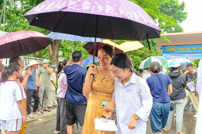Dù vai áo đã ướt mưa, gương mặt nhiều phụ huynh vẫn ánh lên niềm vui và sự nhẹ nhõm khi thấy con hoàn thành môn thi đầu tiên với tâm trạng thoải mái.
