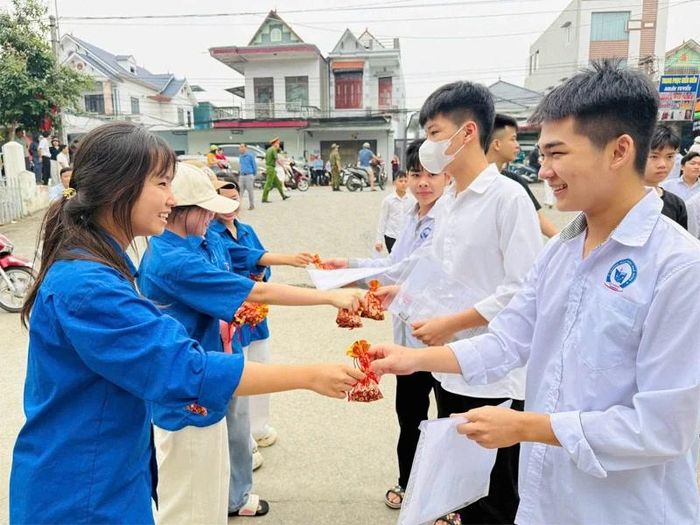 Đoàn viên, thanh niên xã Thiệu Trung trao túi đậu đỏ may mắn cho thí sinh dự thi tại điểm thi Trường THPT Lê Văn Hưu.