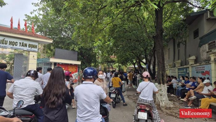 Càng gần đến giờ vào phòng thi, điểm trường Tiểu học Tân Định (Tương Mai, Hà Nội) càng đông đúc, không khí dường như cũng nóng lên cùng tâm trạng hồi hộp của thí sinh và phụ huynh. Giờ phát đề môn Ngữ văn là 7h30 và giờ bắt đầu làm bài 7h35.
