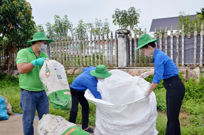 Đoàn viên, thanh niên Xã đoàn Hòn Đất hỗ trợ người dân phân loại, ghi nhận số lượng vỏ chai, bao gói thuốc bảo vệ thực vật để đổi quà. Ảnh: MI NI