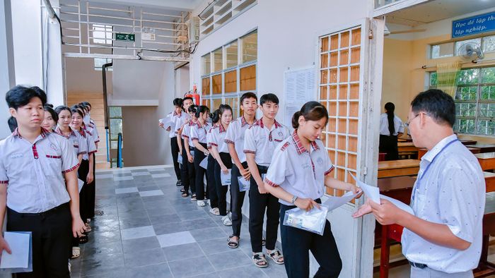Cán bộ coi thi tại điểm thi Trường THPT Thoại Ngọc Hầu gọi thí sinh vào phòng thi. Ảnh: THANH NHÃ
