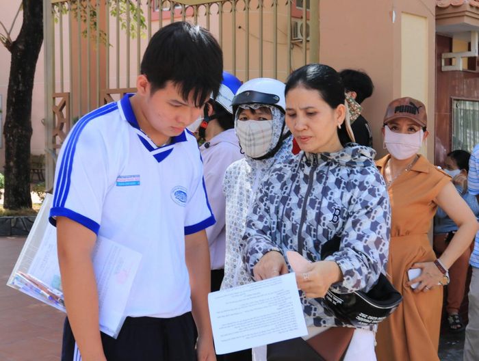Thí sinh tại điểm thi Trường THPT chuyên Thoại Ngọc Hầu, phường Long Xuyên trao đổi về đề thi cùng phụ huynh sau giờ thi. Ảnh: NGUYỄN HƯNG