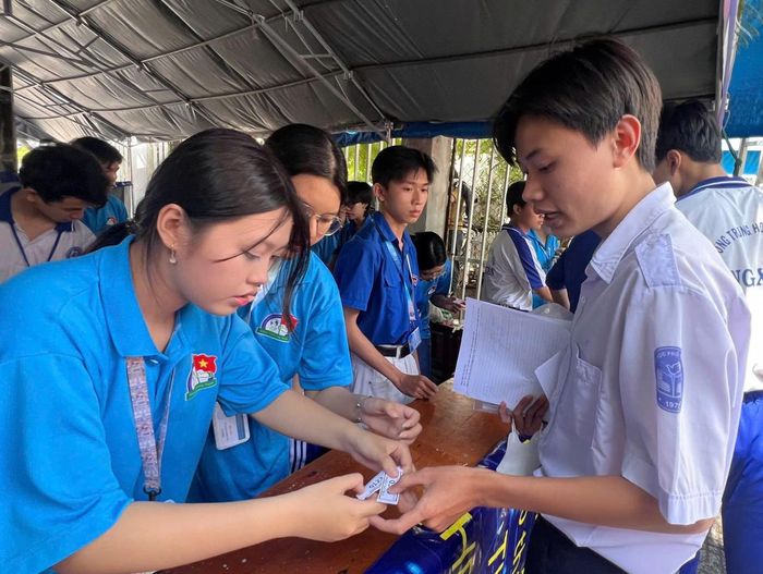 Thí sinh tại điểm thi Trường THPT Long Xuyên nhận lại tư trang sau giờ thi. Ảnh: NGUYỄN HƯNG