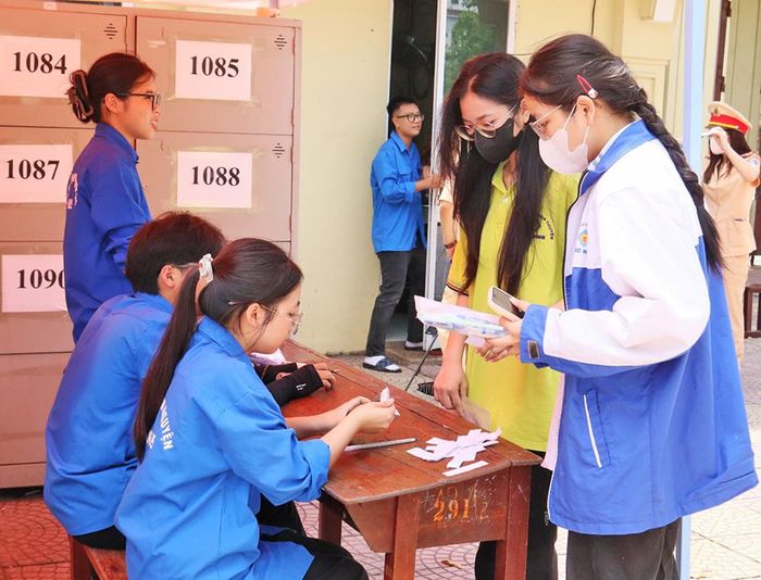 Hỗ trợ trả đồ cho thí sinh sau khi kết thúc môn thi Ngữ văn tại Điểm thi Trung học phổ thông Hàn Thuyên.
