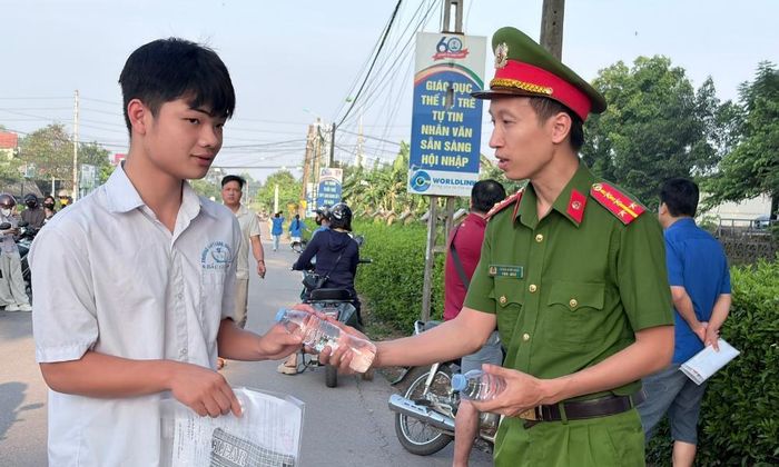 Công an xã Lạng Giang phát nước cho thí sinh Trường Trung học phổ thông Lạng Giang số 1.