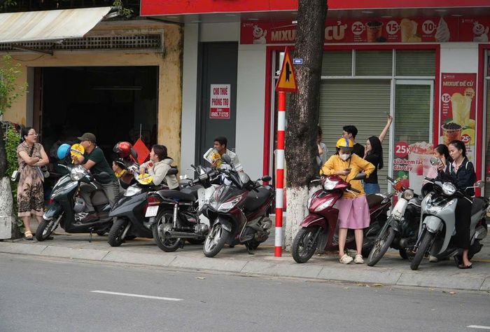 Phụ huynh đứng đợi con trước điểm thi Trường THPT Phan Bội Châu. Ảnh: HỒ QUÂN