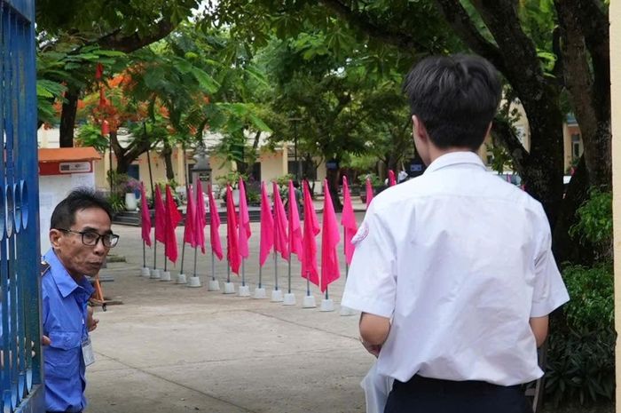 Thí sinh đi trễ, được cán bộ làm nhiệm vụ tại điểm thi Trường THPT Phan Bội Châu (phường Hương Trà) hỗ trợ vào thi. Ảnh: HỒ QUÂN