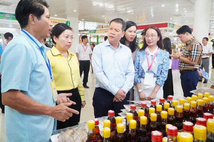 Chủ tịch UBND thành phố Nguyễn Mạnh Hùng nghe chủ doanh nghiệp, hợp tác xã giới thiệu về sản phẩm. Ảnh: VINH ANH