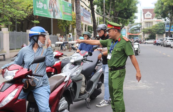 Lực lượng công an hướng dẫn người dân đậu xe đúng nơi quy định. Ảnh chụp tại điểm thi Trường THPT Trần Phú (phường Hải Châu). Ảnh: NGỌC HÀ
