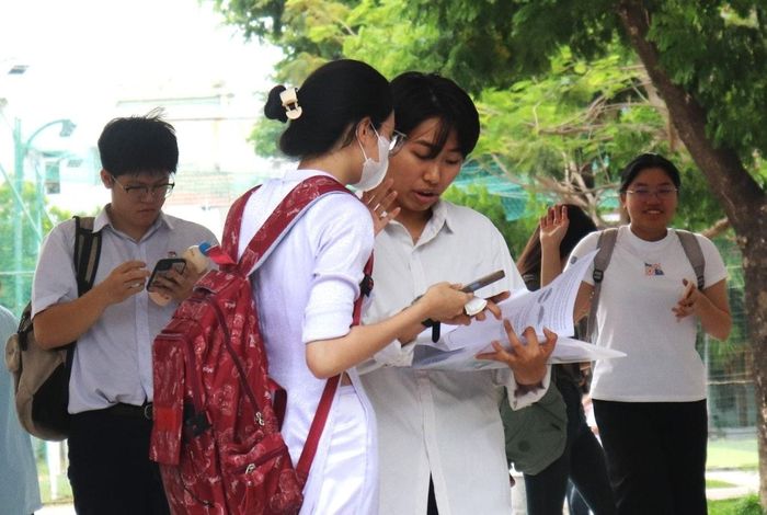 Thí sinh trao đổi bài thi môn Toán. Ảnh: NGỌC HÀ