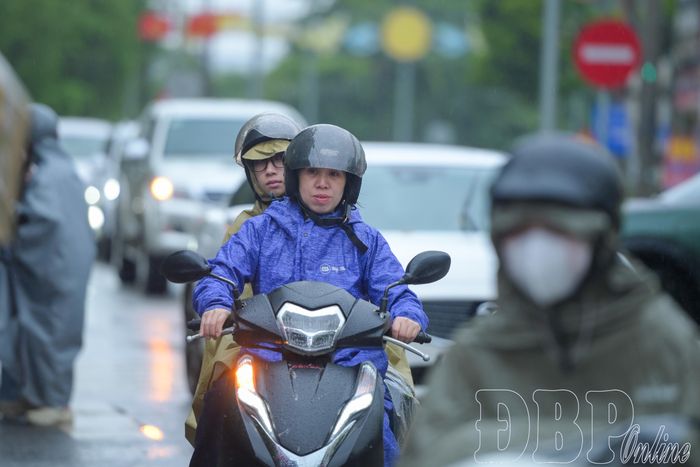Tuy trời đổ mưa nhưng nhiều phụ huynh đưa con đến điểm thi từ sớm, động viên các em trước giờ làm bài.