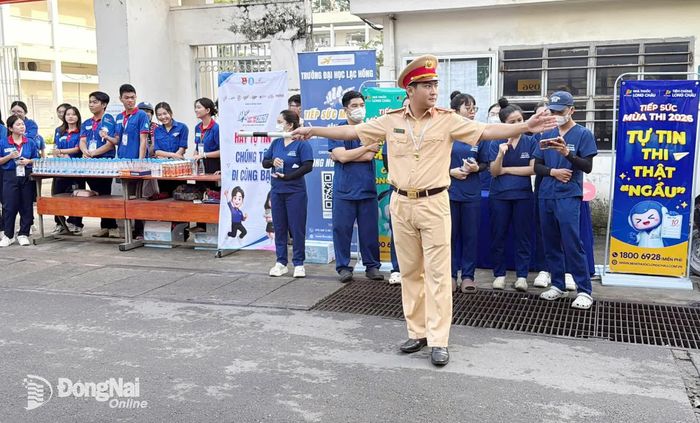Cảnh sát giao thông hướng dẫn, phân luồng giao thông trước cổng Trường THPT Nguyễn Hữu Cảnh (phường Long Hưng), bảo đảm an toàn cho thí sinh và phụ huynh trong ngày đầu kỳ thi. Ảnh: Lê Duy