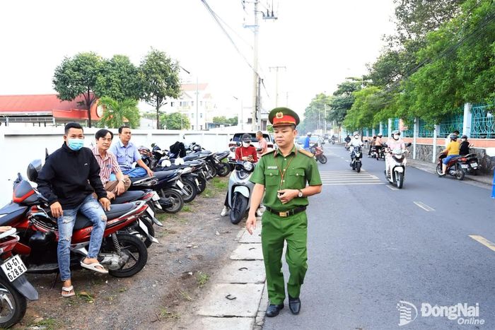 Công an phường Tam Hiệp hỗ trợ đảm bảo an ninh trật tự trước điểm thi. Ảnh: Công Nghĩa