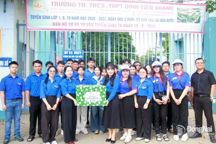 Phó Bí thư Thành đoàn, Chủ tịch Hội Sinh viên thành phố, Chủ tịch Hội đồng Đội thành phố Nguyễn Trần Phương Hà tặng quà đội hình tiếp sức mùa thi tại điểm thi Trường TH-THCS-THPT Đinh Tiên Hoàng, phường Tam Hiệp. Ảnh: Nga Sơn