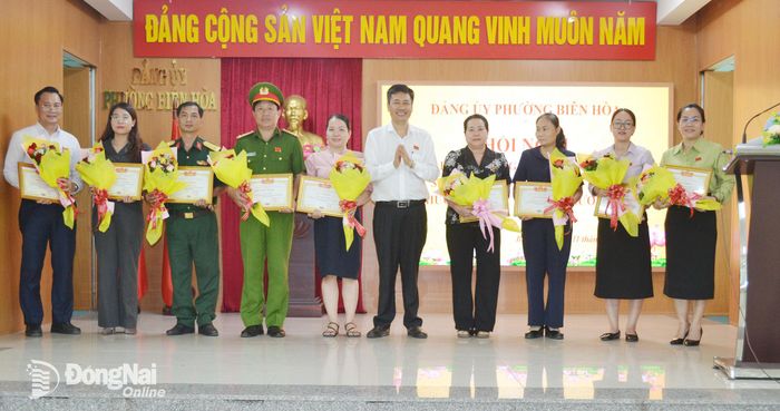 Thành ủy viên, Bí thư Đảng ủy, Chủ tịch HĐND phường Biên Hòa Viên Hồng Tiến khen thưởng các tập thể, cá nhân có thành tích xuất sắc trong thực hiện mô hình tổ chức chính quyền địa phương 2 cấp trên địa bàn phường. Ảnh: Phương Hằng