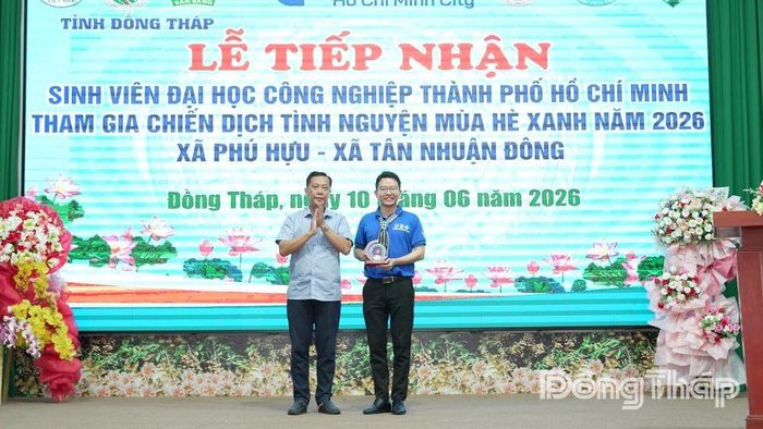 Đồng chí Lê Minh Trung, Bí thư Đảng ủy, Chủ tịch HĐND xã Phú Hựu trao biểu trưng lưu niệm cho đại diện Trường Đại học Công nghiệp TP.HCM.