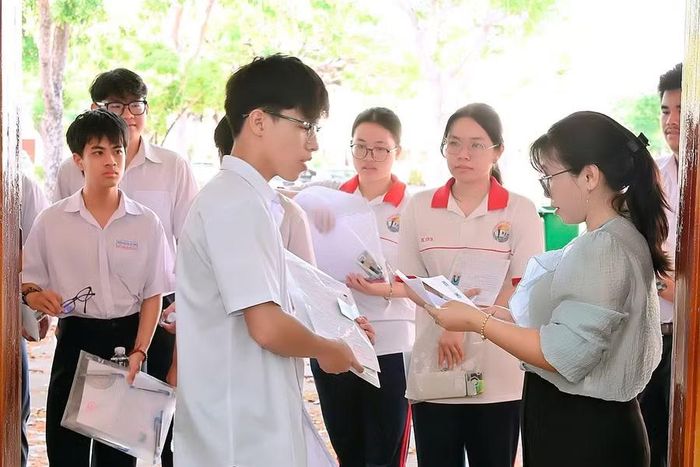  Cán bộ coi thi kiểm tra thông tin thí sinh trước khi vào phòng thi. Ảnh: Đức Thụy 