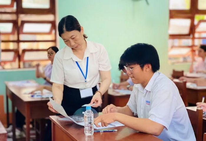  Cán bộ coi thi phát giấy thi cho thí sinh. Ảnh: Trần Dung 