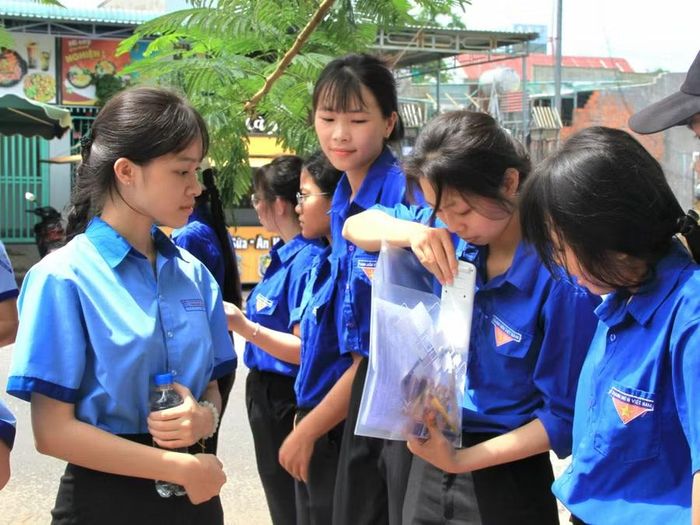  Đoàn viên thanh niên xã Phú Thiện hỗ trợ, nhắc nhở thí sinh kiểm tra giấy tờ và dụng cụ được phép mang vào phòng thi. Ảnh: Hoàng Hoài 