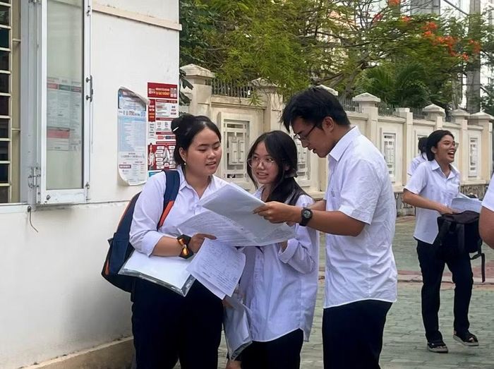  Các thí sinh tranh thủ trao đổi nhanh đáp án, chia sẻ về đề thi môn Toán ngay sau khi hoàn thành bài thi. Ảnh: Huỳnh Vỹ 