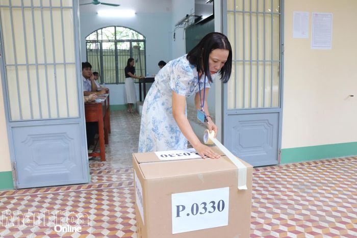 Giám thị tại điểm thi Trường THPT Nguyễn Thiện Thuật dán thùng đựng đồ dùng của thí sinh để đưa về khu vực cách xa phòng thi 25m.
