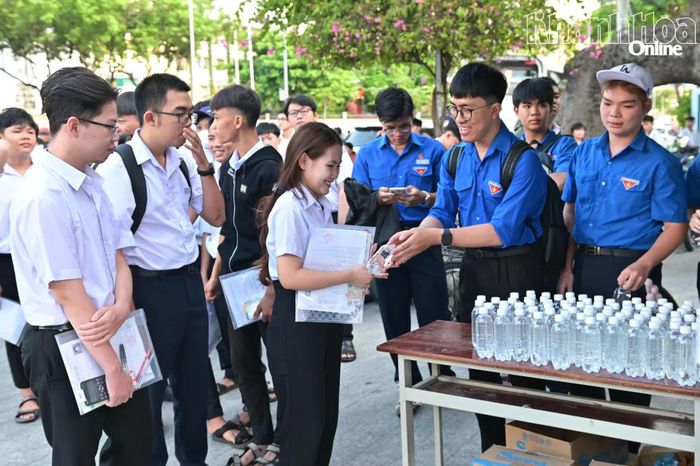 Các tình nguyện viên tại điểm thi Trường THCS Thái Nguyên phát nước uống miễn phí cho thí sinh và sẵn sàng hỗ trợ khi cần thiết.