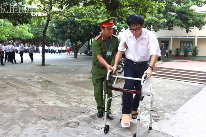 Thí sinh Nguyễn Đức Hoàng, học sinh Trường THPT Lý Tự Trọng (phường Nha Trang) bị gãy chân được cán bộ công an hỗ trợ đưa vào phòng thi tại điểm thi Trường THPT Nguyễn Thiện Thuật (phường Nha Trang).