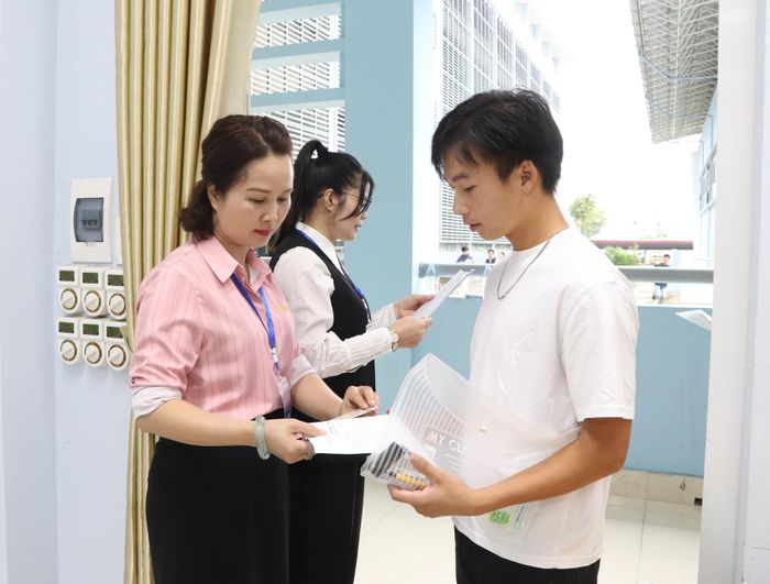 Giám thị kiểm tra thông tin thí sinh trước khi vào phòng thi.
