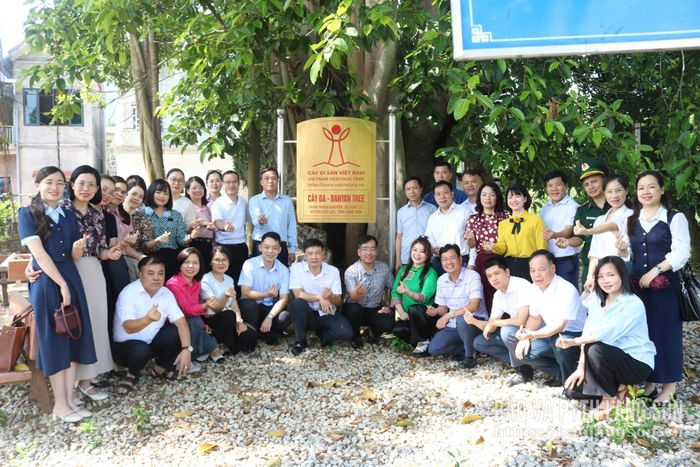 Các cán bộ, đảng viên chụp ảnh lưu niệm tại cây đa thôn Thạch Khuyên, nơi lực lượng du kích thảo luận để tìm cách đánh đồn giặc 