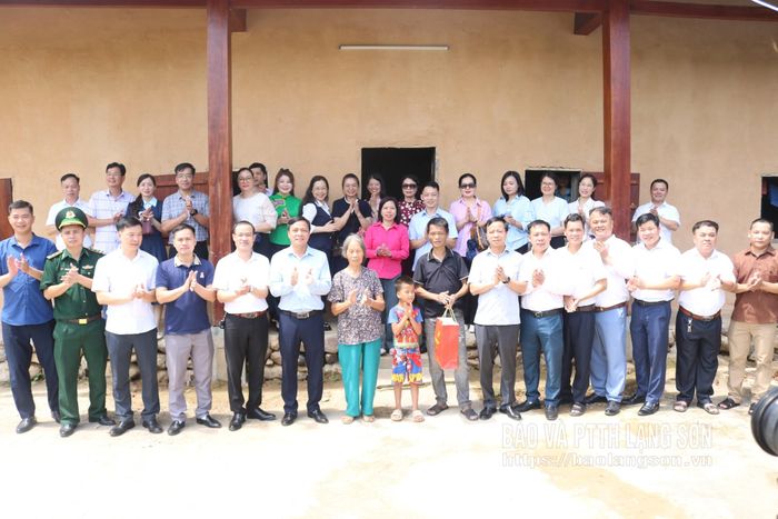 Các cán bộ, đảng viên tặng quà và chụp ảnh lưu niệm cùng hộ gia đình thôn Thạch Khuyên, xã Ba Sơn