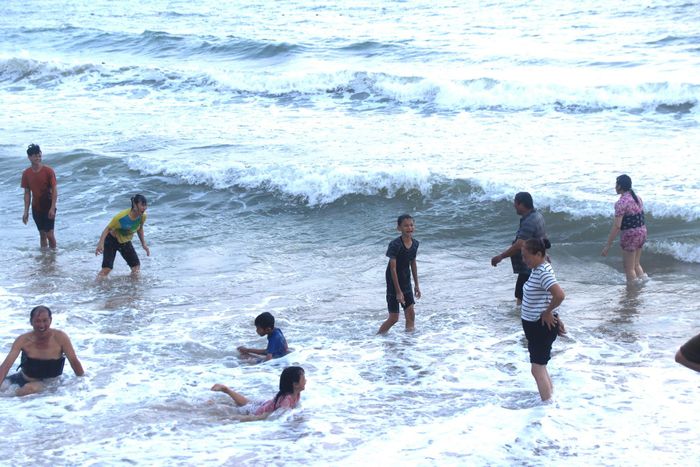 Du khách và người dân vui chơi, tắm biển.