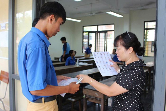 Cán bộ coi thi kiểm tra thông tin thí sinh trước khi vào phòng thi tại Điểm thi Trường THPT Phan Bội Châu - Phan Thiết