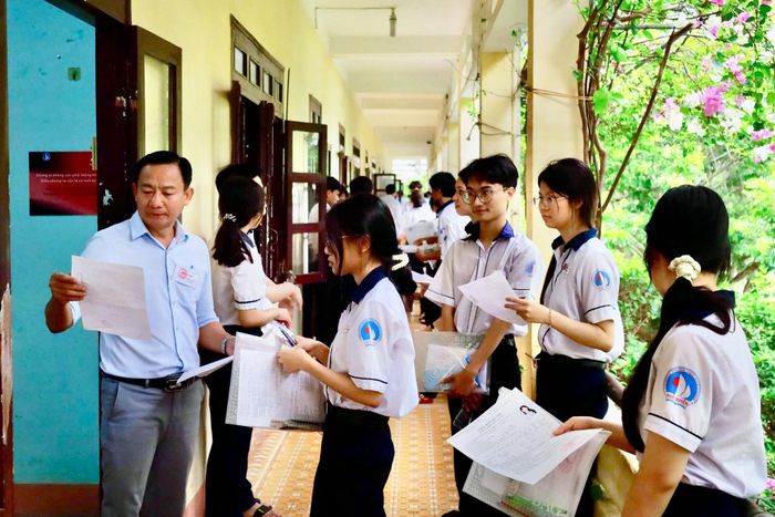 Giám thị coi thi điểm danh thí sinh vào phòng thi tại Điểm thi Trường THPT Ngô Quyền