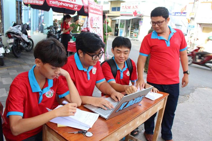 Đội hình Hoa phượng đỏ hỗ trợ thí sinh tra cứu thông tin và hướng dẫn đến đúng phòng thi
