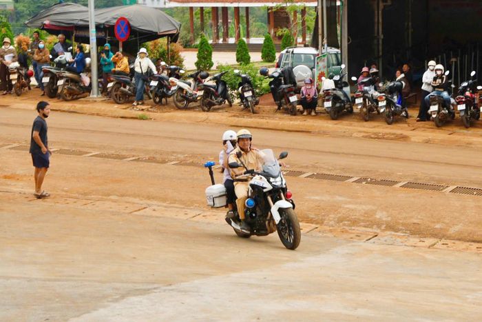 Cảnh sát giao thông hỗ trợ một thí sinh tới điểm thi biên giới Tuy Đức