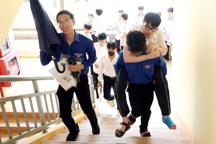 Một thí sinh gặp khó khăn về di chuyển được hỗ trợ lên phòng thi tại Điểm thi Trường THPT Chuyên Nguyễn Chí Thanh