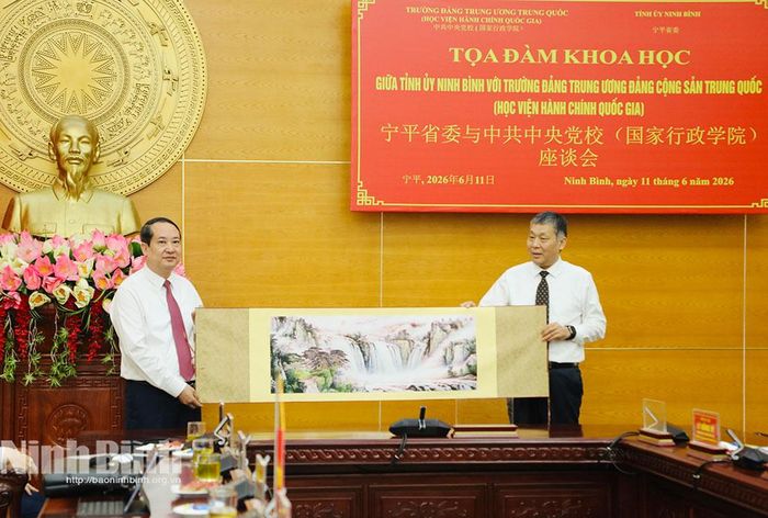 Đồng chí Đổng Chấn Hoa, Trưởng Ban Nghiên cứu giảng dạy Chủ nghĩa xã hội khoa học, Trường Đảng Trung ương Đảng Cộng sản Trung Quốc trao quà lưu niệm cho đồng chí Mai Văn Tuất, Phó Bí thư Tỉnh ủy, Trưởng Đoàn đại biểu Quốc hội tỉnh.