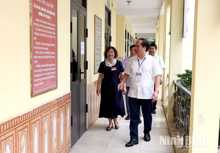 Đồng chí Đinh Văn Khâm, Phó Giám đốc Sở Giáo dục và Đào tạo kiểm tra công tác coi thi tại điểm thi Trường THPT Kim Sơn A. Ảnh: Minh Quang