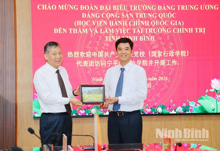 Đồng chí Phan Thành Công, Tỉnh ủy viên, Hiệu trưởng Trường Chính trị tỉnh trao quà lưu niệm cho đồng chí Đổng Chấn Hoa, Trưởng Ban Nghiên cứu và giảng dạy Chủ nghĩa xã hội khoa học, Trường Đảng Trung ương Đảng Cộng sản Trung Quốc.
