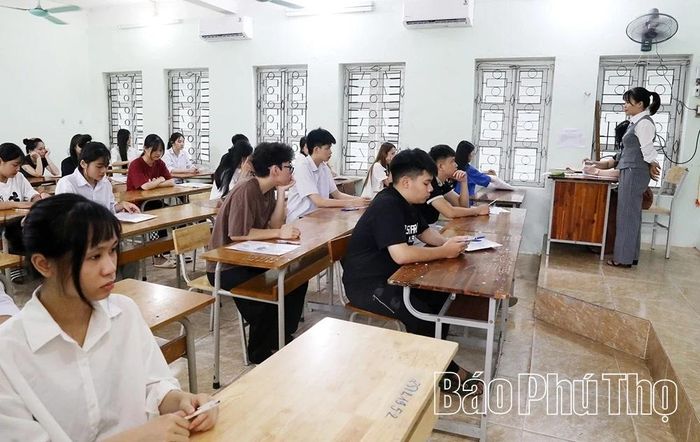 Cán bộ coi thi hướng dẫn thí sinh điền thông tin vào giấy thi