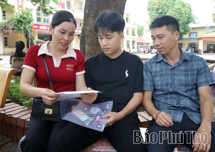 Vợ chồng anh Bùi Văn Triệu động viên con trai trước giờ thi.