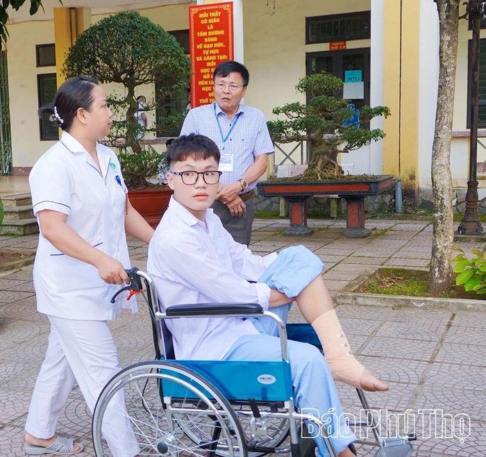 Cán bộ Trung tâm Y tế khu vực Cẩm Khê đưa em Lê Công Sơn đến điểm thi THPT Cẩm Khê trước giờ làm bài sáng 11/6.