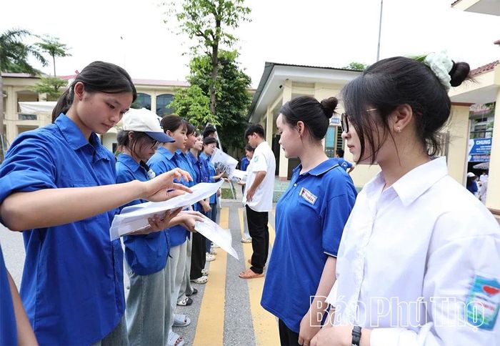 Tình nguyện viên tại điểm thi THPT Thanh Ba hỗ trợ các lực lượng kiểm soát an ninh trước khi vào phòng thi.