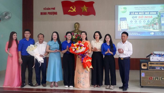 Lãnh đạo phường Bắc Gianh tặng hoa chúc mừng nhóm QR tổ dân phố Minh Phượng - Ảnh: N.M